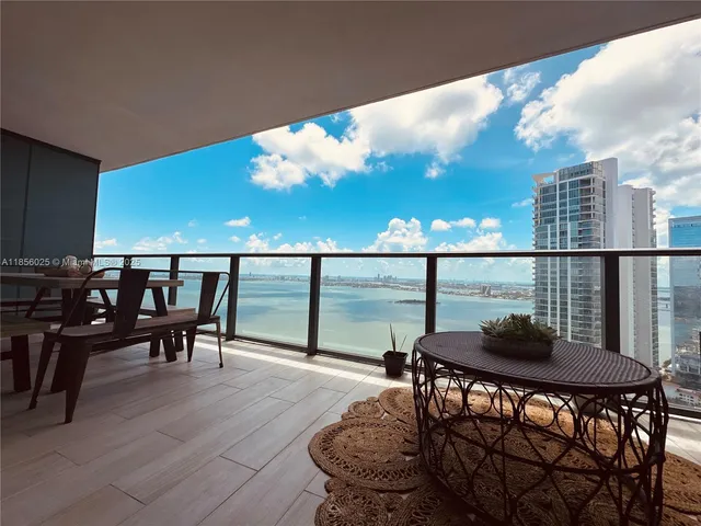 a view of a balcony dining table and chairs