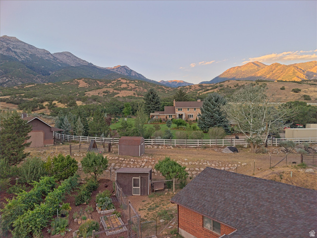 1801 Fort Canyon Road Alpine, UT 84004 - Photo 21 of 26 Expansive property featuring a cultivated garden, multiple outbuildings, a white fence line, and a large dwelling with stone and brick exterior elements