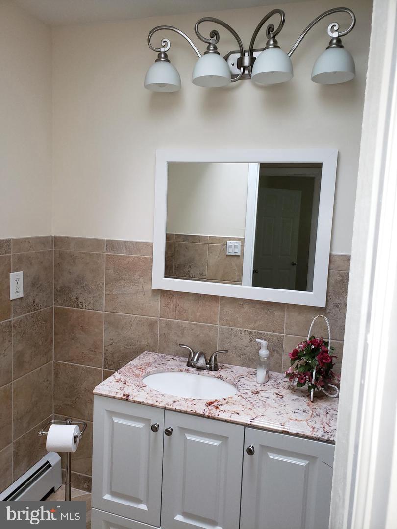 102 Gilbert Road Bordentown, NJ 08505 - Photo 14 of 28 a bathroom with a granite countertop sink a toilet and mirror