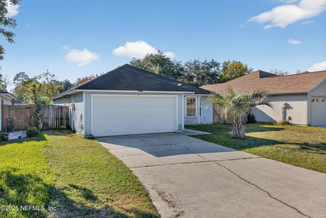 a front view of house with yard and trees in the background