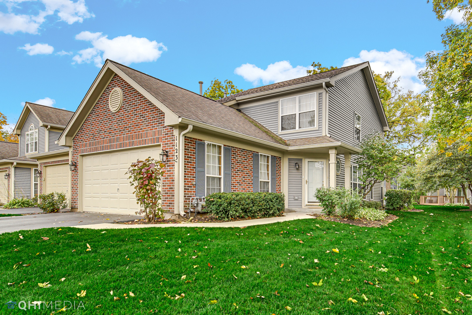 1123 Coldspring Road, Unit 1123 Elgin, IL 60120 - Photo 1 of 23 a view of a house with brick walls and a yard with plants