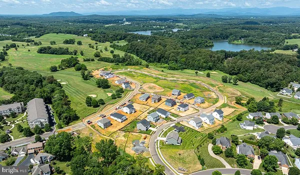 an aerial view of residential houses with outdoor space and trees