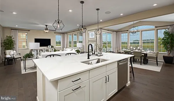 a kitchen with counter top space a sink and living room view