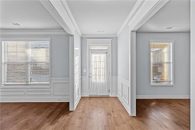 an empty room with wooden floor and windows