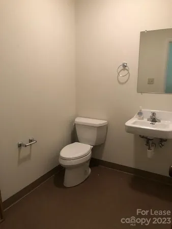 a bathroom with a toilet a sink and mirror