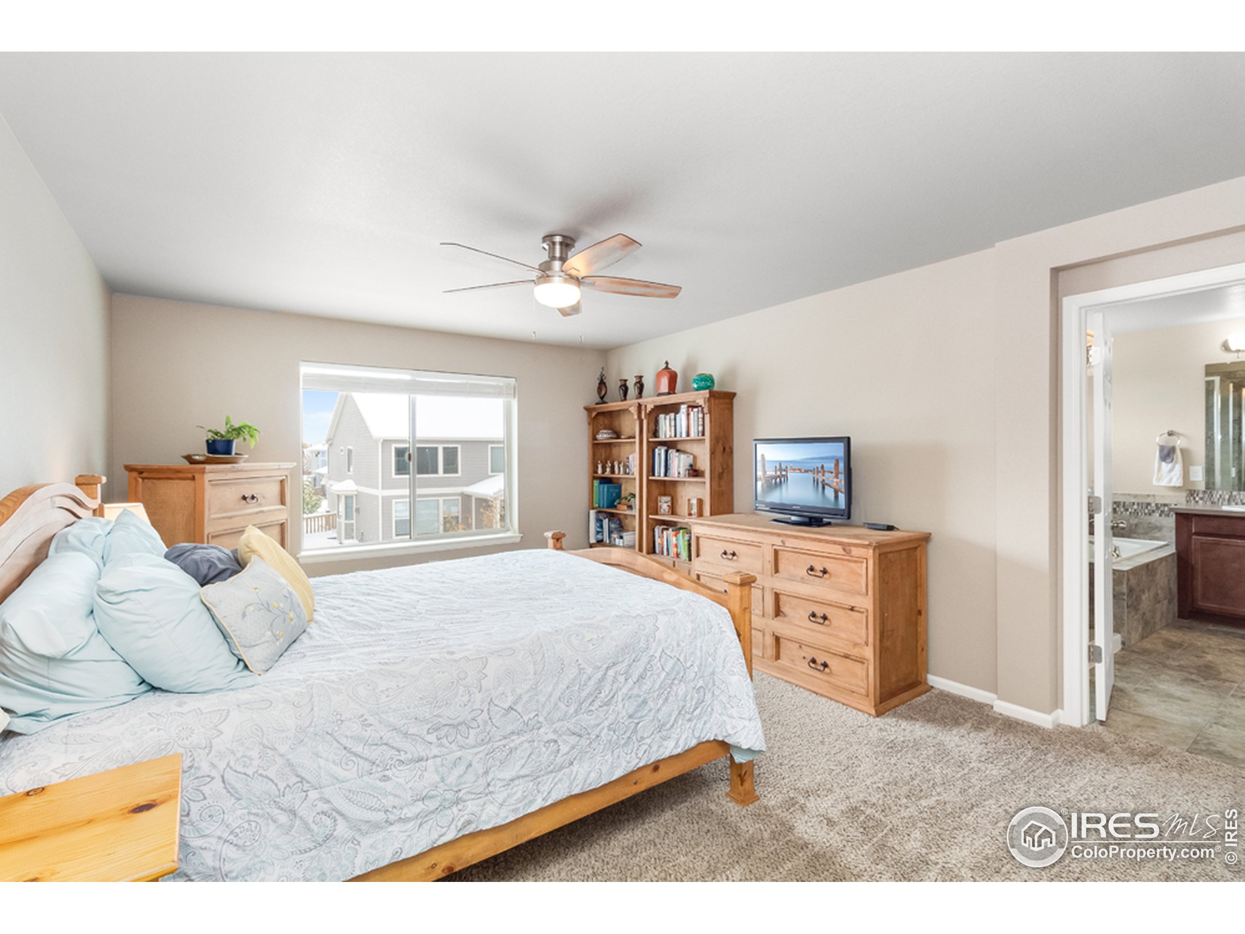 6559 Tombstone Ridge Road Timnath, CO 80547 - Photo 15 of 30 a bedroom with a large bed and a dresser