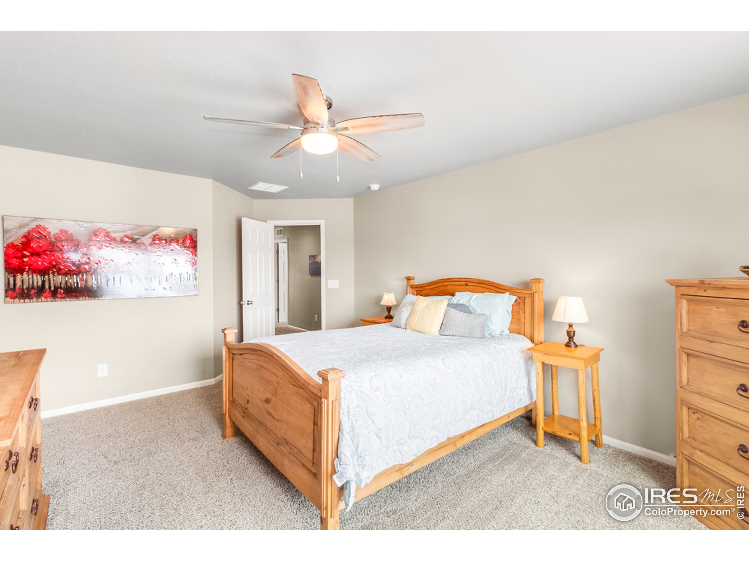 6559 Tombstone Ridge Road Timnath, CO 80547 - Photo 16 of 30 a bedroom with a bed and a chandelier