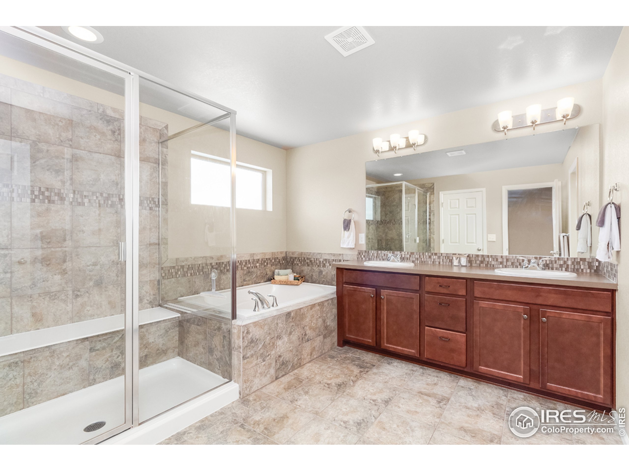 6559 Tombstone Ridge Road Timnath, CO 80547 - Photo 17 of 30 a spacious bathroom with a tub sink shower and mirror