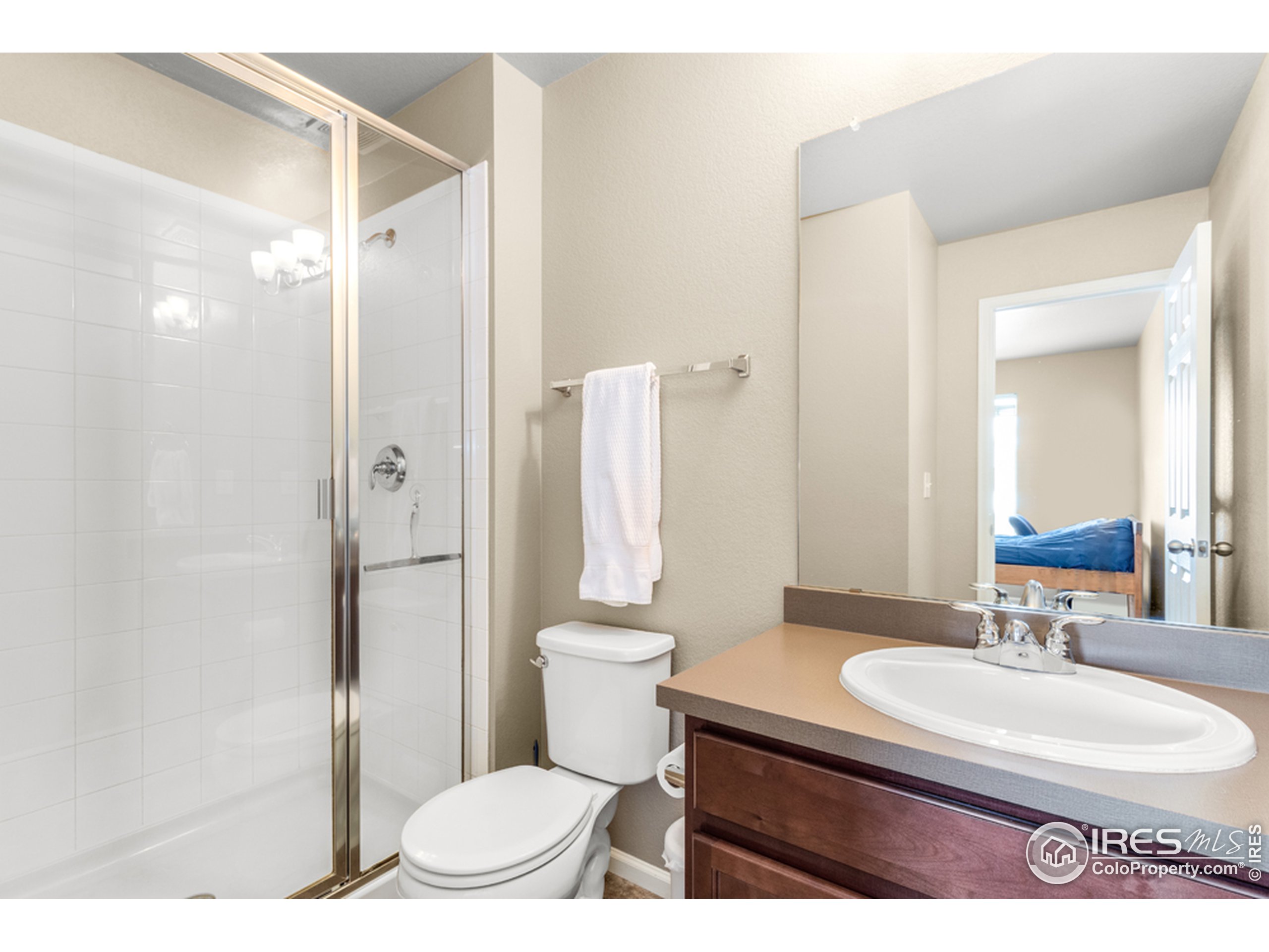 6559 Tombstone Ridge Road Timnath, CO 80547 - Photo 22 of 30 a bathroom with a sink a toilet a mirror and shower