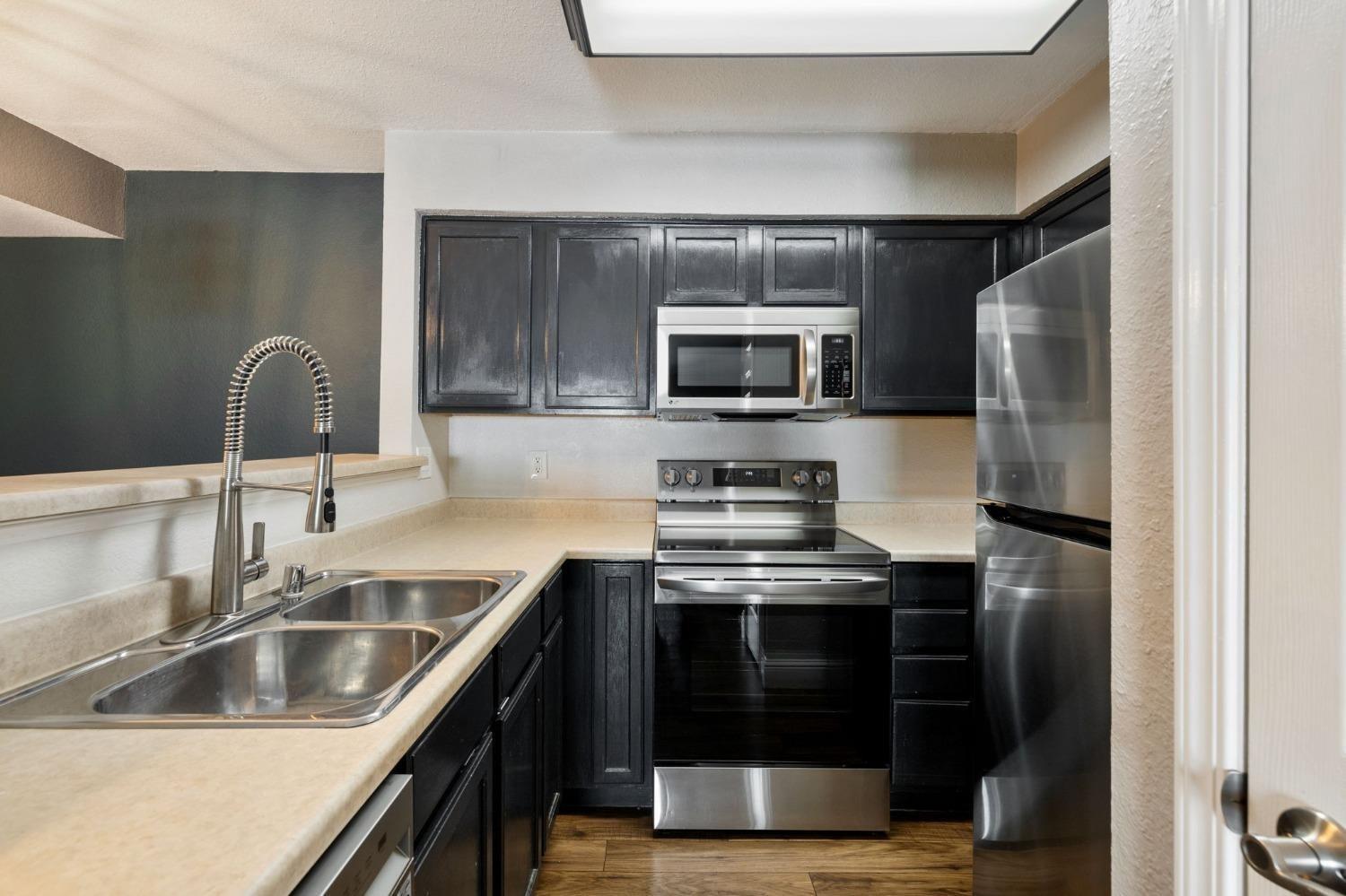 2881 Huntington Boulevard, Unit 212 Fresno, CA 93721 - Photo 6 of 17 a kitchen with a sink stove and refrigerator