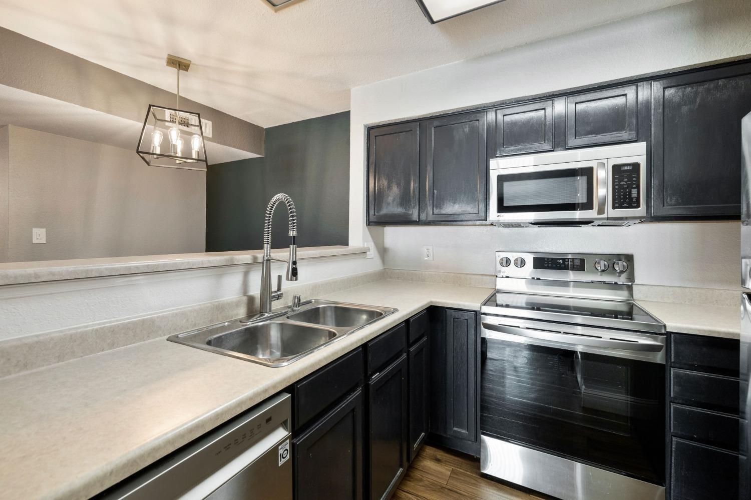 2881 Huntington Boulevard, Unit 212 Fresno, CA 93721 - Photo 7 of 17 a kitchen with a sink and stainless steel appliances