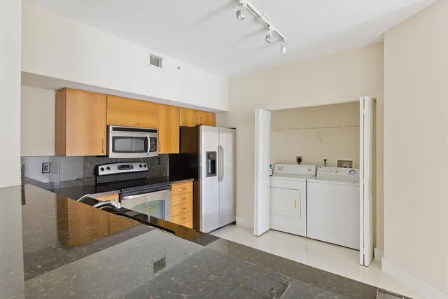 a kitchen with stainless steel appliances granite countertop a refrigerator and a stove top oven