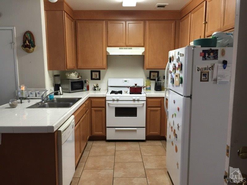 220 East 7th Street Oxnard, CA 93030 - Photo 4 of 9 a kitchen with stainless steel appliances a stove a sink and a refrigerator