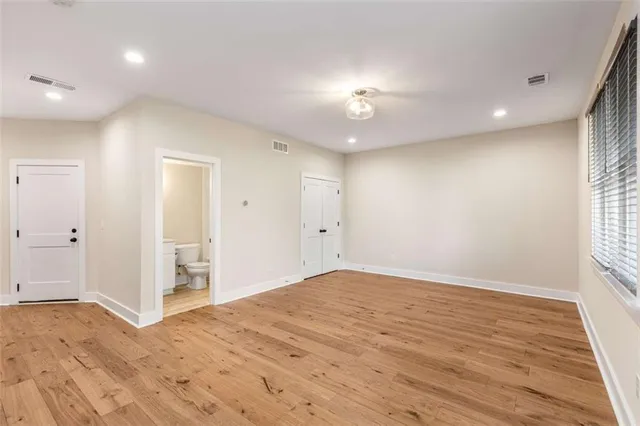 a view of an empty room with wooden floor