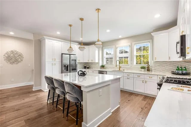a kitchen with a sink stainless steel appliances and white cabinets
