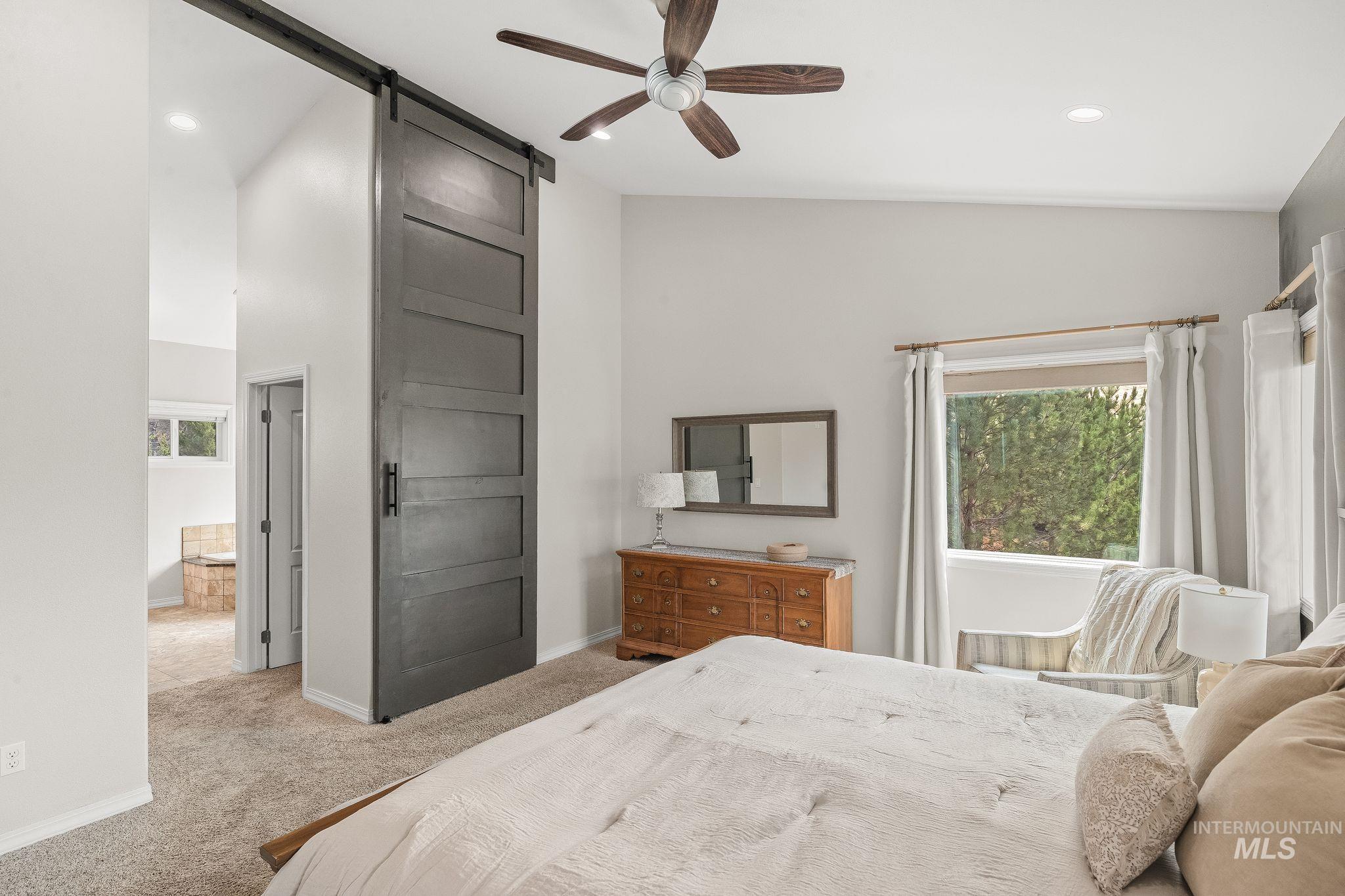602 Quarry Road Asotin, WA 99402 - Photo 29 of 49 Spacious room featuring a dark wood-finish barn door, vaulted ceilings, and recessed lighting