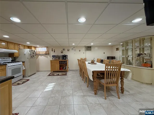 a dining room with stainless steel appliances a dining table and chairs