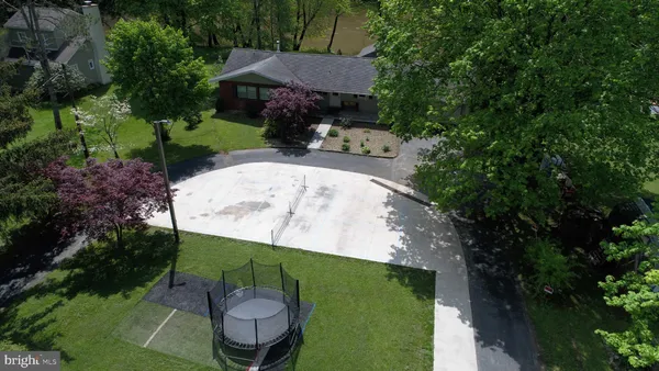 an aerial view of a house with a yard and trees all around