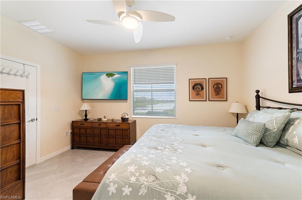 2652 Vine Avenue Naples, FL 34120 - Photo 12 of 40 a bedroom with a bed and a flat screen tv