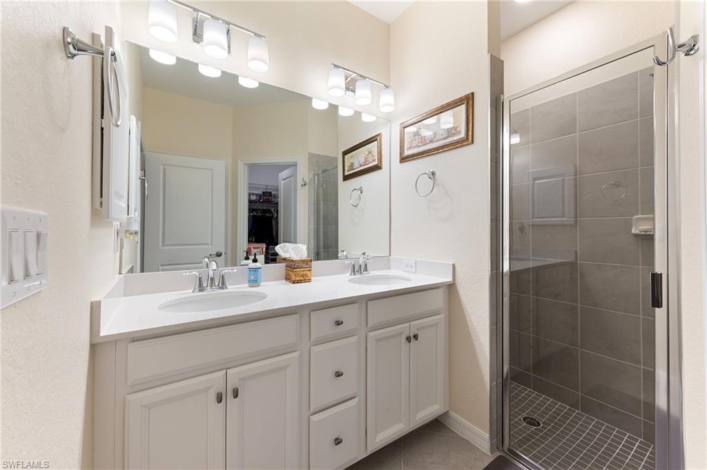 2652 Vine Avenue Naples, FL 34120 - Photo 13 of 40 a bathroom with a double vanity sink mirror and shower