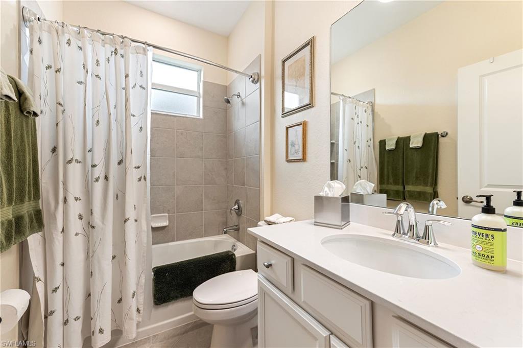 2652 Vine Avenue Naples, FL 34120 - Photo 16 of 40 a bathroom with a granite countertop sink toilet and shower