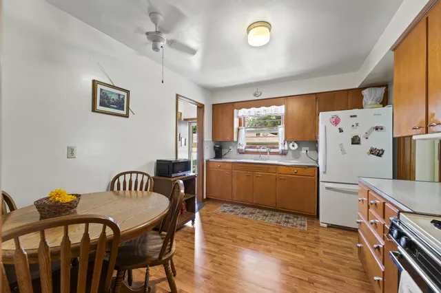 a kitchen with stainless steel appliances kitchen island granite countertop a table chairs and a refrigerator