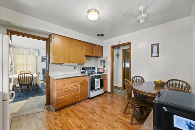 a kitchen with a table chairs and a refrigerator