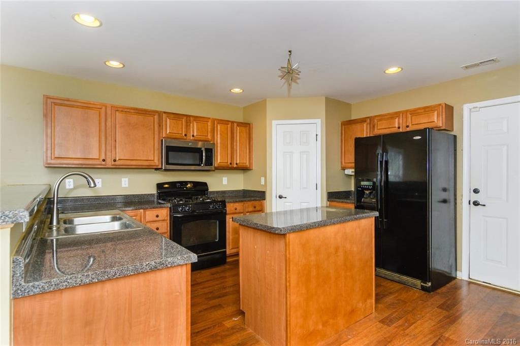 87 Yadkin Road, Unit 327 Fletcher, NC 28732 - Photo 13 of 23 a kitchen with stainless steel appliances granite countertop a refrigerator a stove top oven a sink and dishwasher
