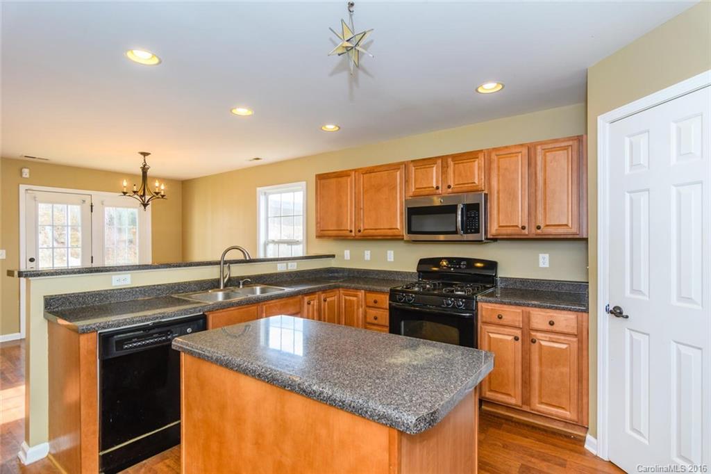 87 Yadkin Road, Unit 327 Fletcher, NC 28732 - Photo 14 of 23 a kitchen with stainless steel appliances granite countertop a sink stove and refrigerator