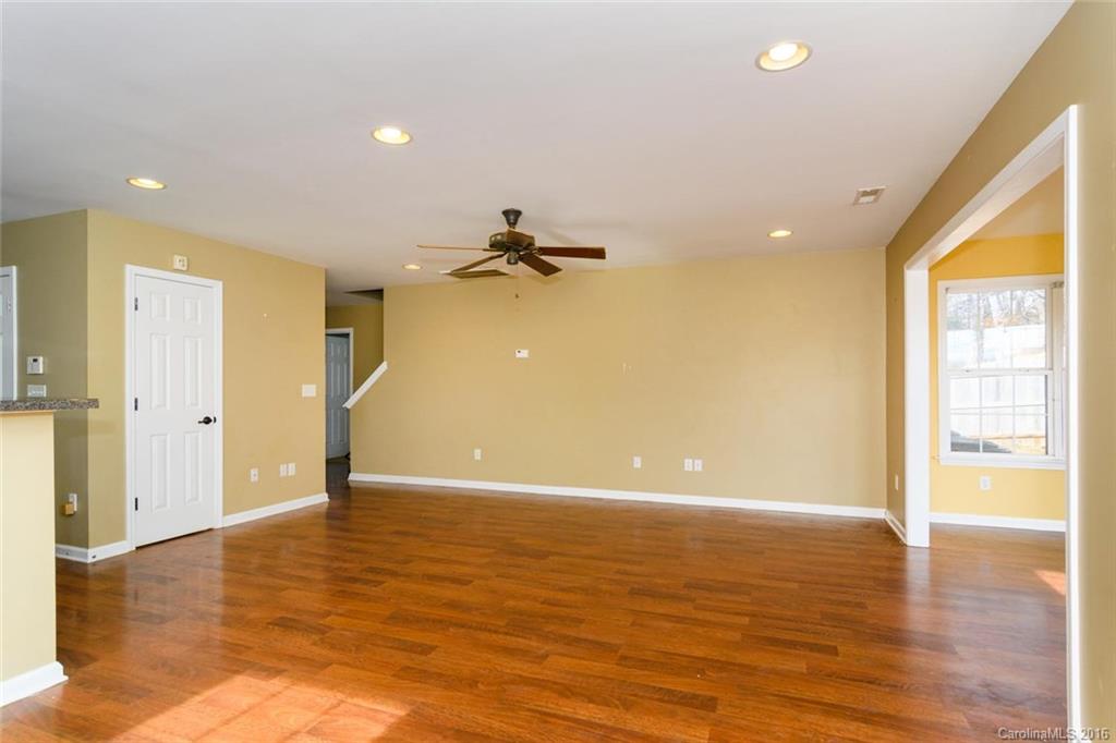 87 Yadkin Road, Unit 327 Fletcher, NC 28732 - Photo 9 of 23 a view of an empty room with wooden floor and a window