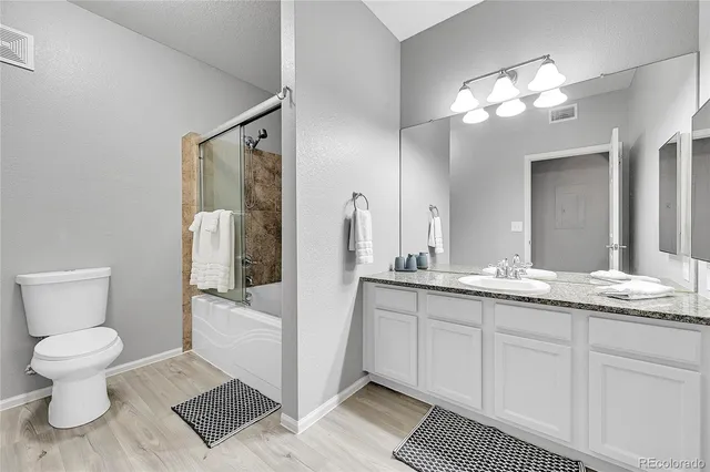 a bathroom with a granite countertop sink a toilet and a mirror