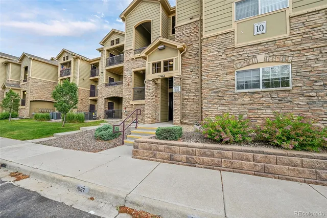 a front view of a house with a yard and potted plants