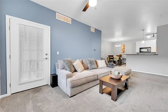 a living room with furniture and a potted plant