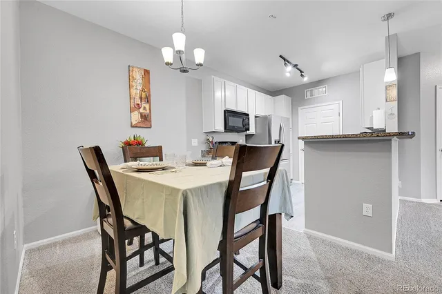 a view of a dining room with furniture and a chandelier