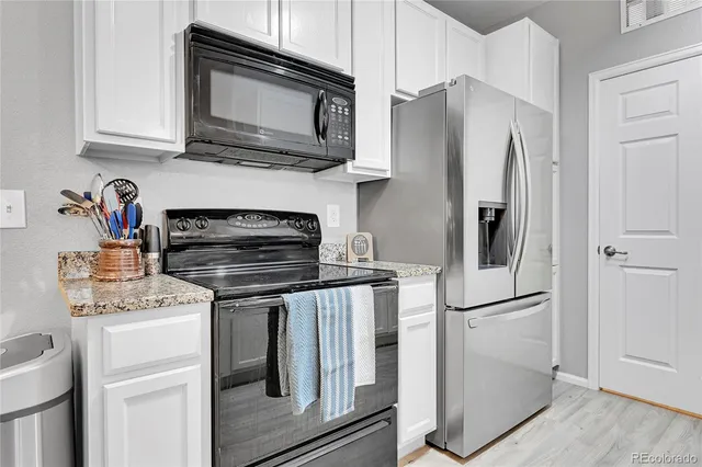 a kitchen with stainless steel appliances granite countertop a refrigerator stove and microwave