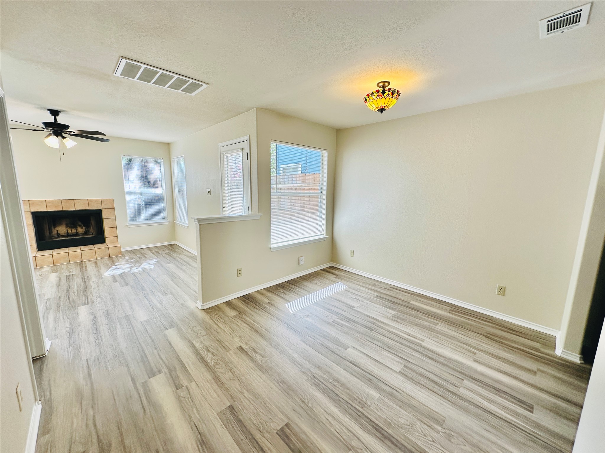 8814 Schick Road, Unit C Austin, TX 78729 - Photo 6 of 35 Luminous living space featuring durable vinyl plank flooring and a cozy corner fireplace.