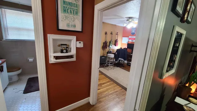 a view of a hallway with bathroom and wooden floor