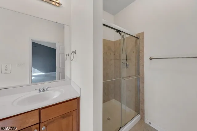 a bathroom with a shower sink and mirror
