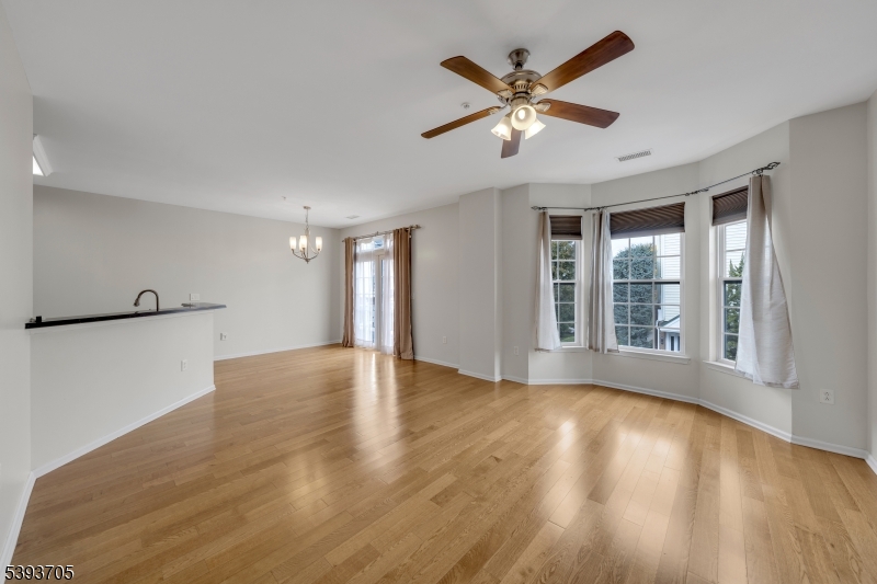 805 Deluca Road, Unit 805 Belleville, NJ 07109 - Photo 5 of 35 a view of an empty room with wooden floor and a window