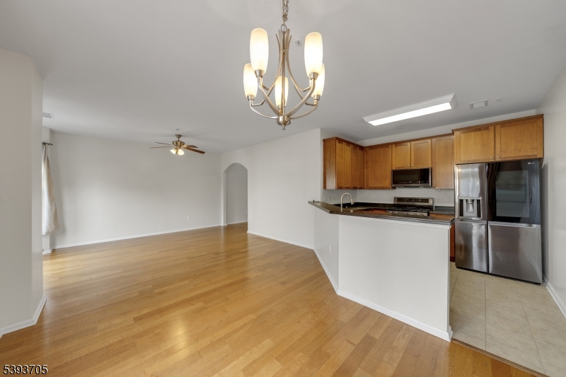 805 Deluca Road, Unit 805 Belleville, NJ 07109 - Photo 9 of 35 a kitchen with stainless steel appliances granite countertop a refrigerator a sink dishwasher a stove and a dining table with wooden floor
