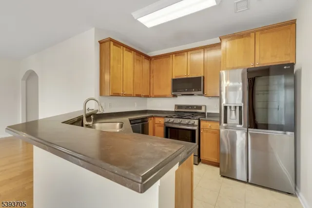 a kitchen with stainless steel appliances granite countertop a sink a stove and a refrigerator