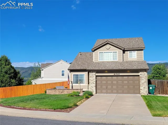 a front view of a house with a garden and garage