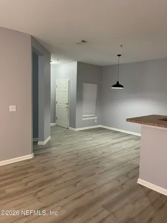 a view of an empty room with wooden floor