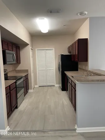 a kitchen with stainless steel appliances kitchen island granite countertop a stove a sink and a refrigerator