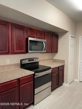 a kitchen with sink a microwave a stove and cabinets