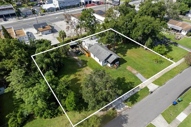 an aerial view of a tennis ground and a cars park side of the road