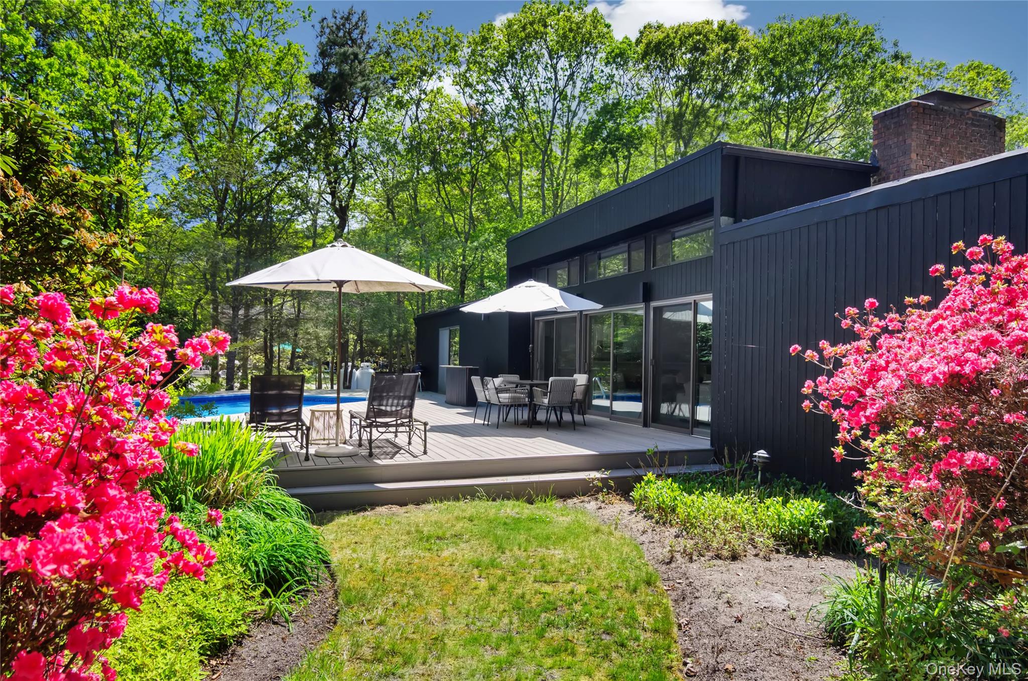 24 North Quarter Road Westhampton, NY 11977 - Photo 21 of 27 a patio with a table and chairs under an umbrella