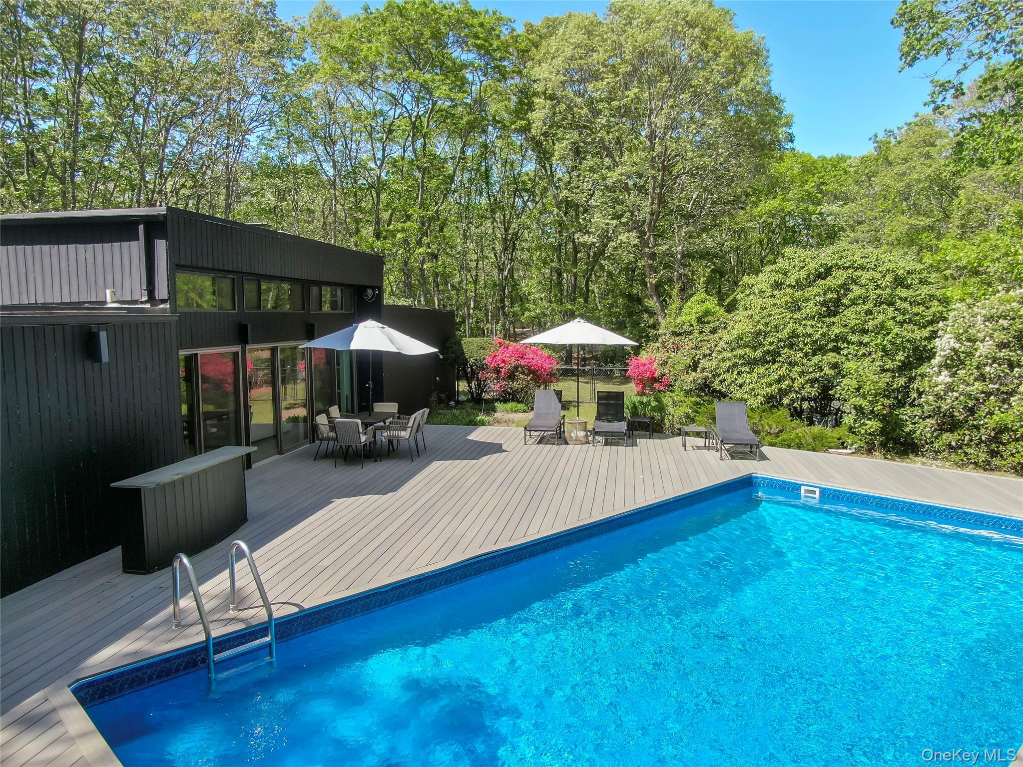 24 North Quarter Road Westhampton, NY 11977 - Photo 22 of 27 a view of a roof deck with table and chairs under an umbrella with wooden floor