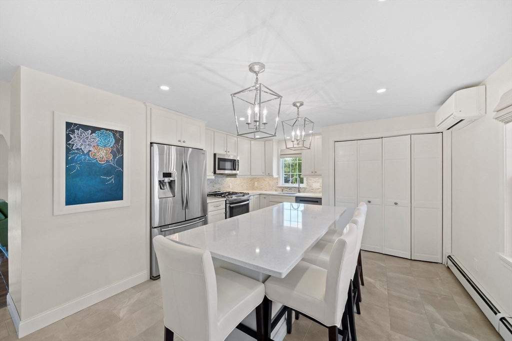 103 Williston Road Bourne, MA 02562 - Photo 4 of 40 a view of a dining room with furniture a chandelier and wooden floor