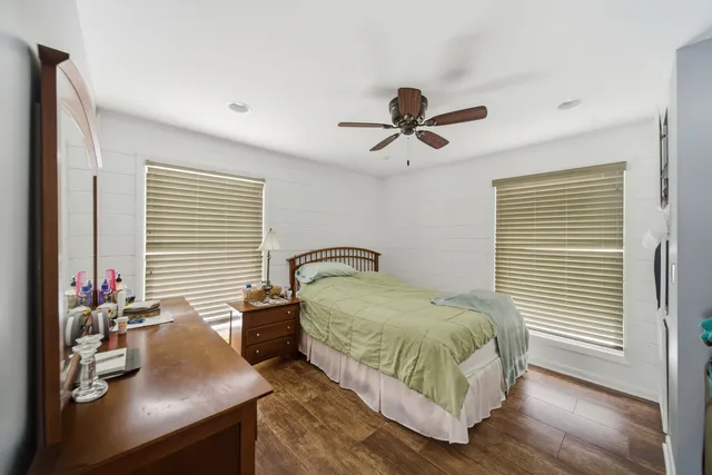 a bedroom with a bed a dresser and a window